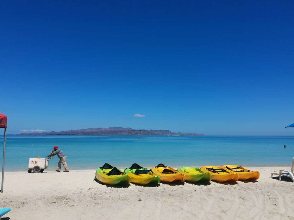 Man selling ice cream on the beach at Playa Tecolote and kayaks for rent