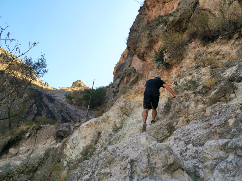 Climbing over a ledge on a hike in Mexico
