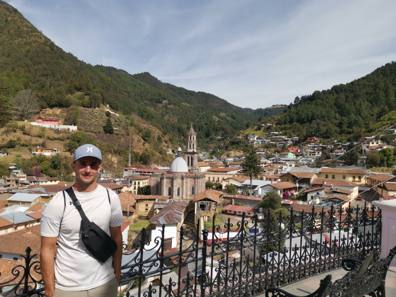 A man overlooking Angangueo's houses and church in a valley