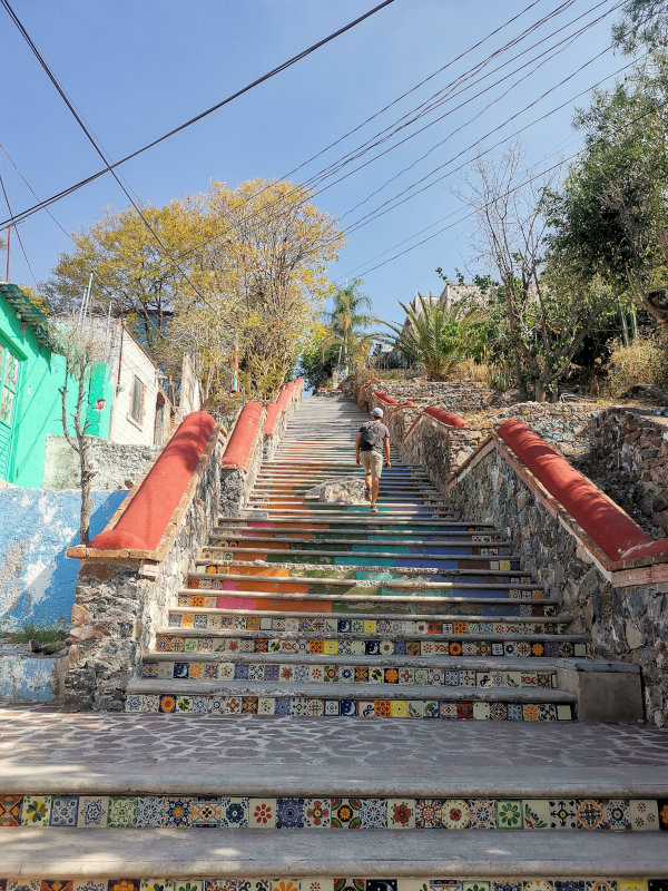 Allan walking up the hill on colorful stairs