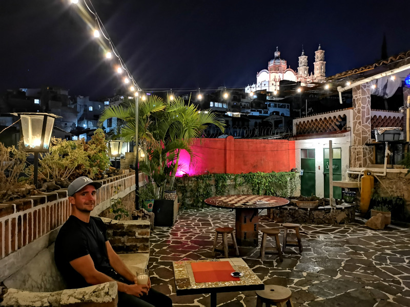 Allan sitting in the outdoor area of Yolotl with a glass of pulque in his hand