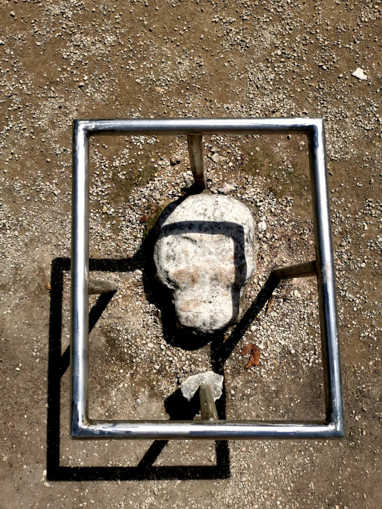 Skull carving in the center of a mayan ball court at some ruins in mexico