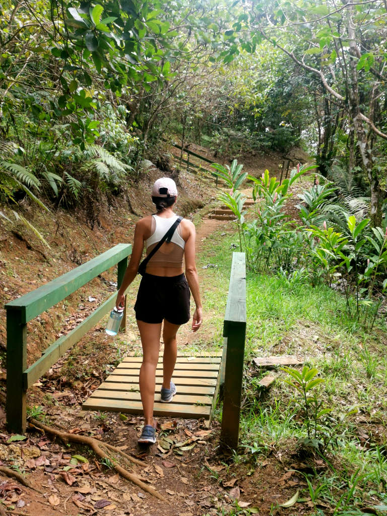 A woman in sport outfit walking over a wodden brige at the beginning of Mount Qua Qua