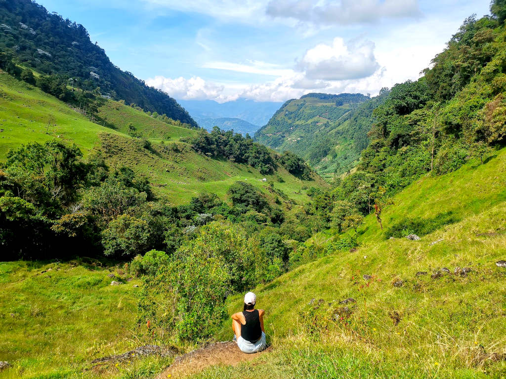 A woman overlooking a green valley outside Jardin