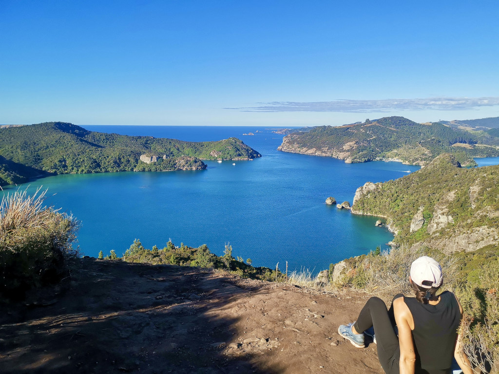 A woman sitting down enjoying the view from the top of the Dukes Nose Hike