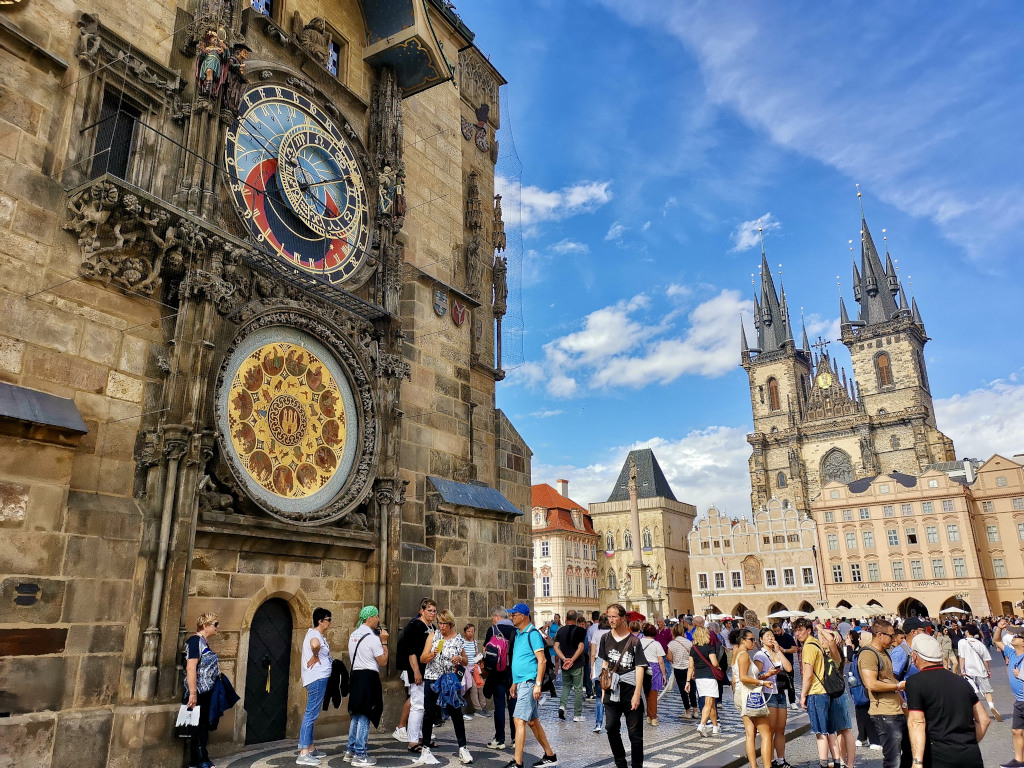 Tourists walking across Old Town Square near the colorful Astronomical Clock, a great starting point for a 2-Day Prague itinerary.