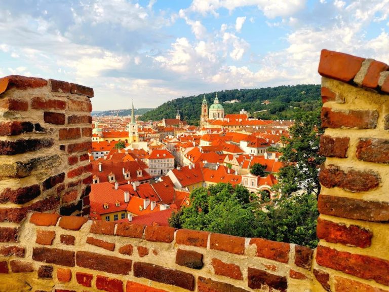 A panoramic view over Prague's Malá Strana framed by the red brick walls of Prague Castle, a must-visit on a 2-Day Prague itinerary.