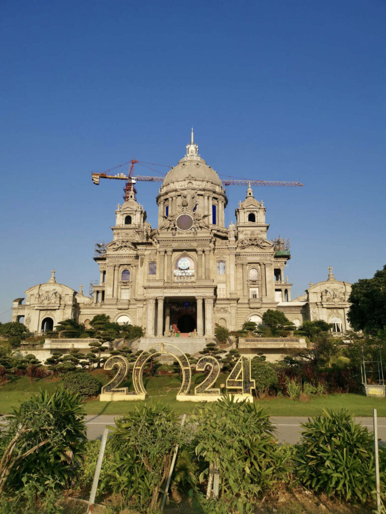 A massive, modern building under construction with a large dome and a "2024" sign in front, showcasing the unique and ambitious architecture found in parts of Ninh Binh
