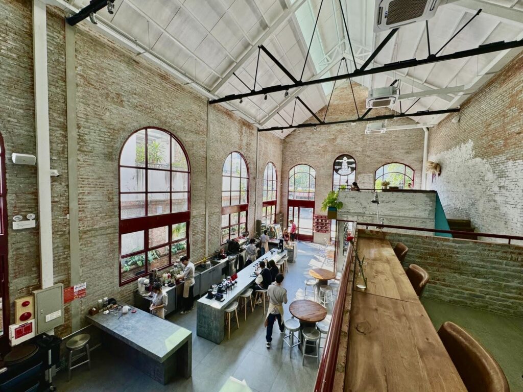 Interior of Lighthouse Cafe in Da Nang, showcasing the high ceilings, exposed brick walls, and open layout popular with digital nomads and remote workers.