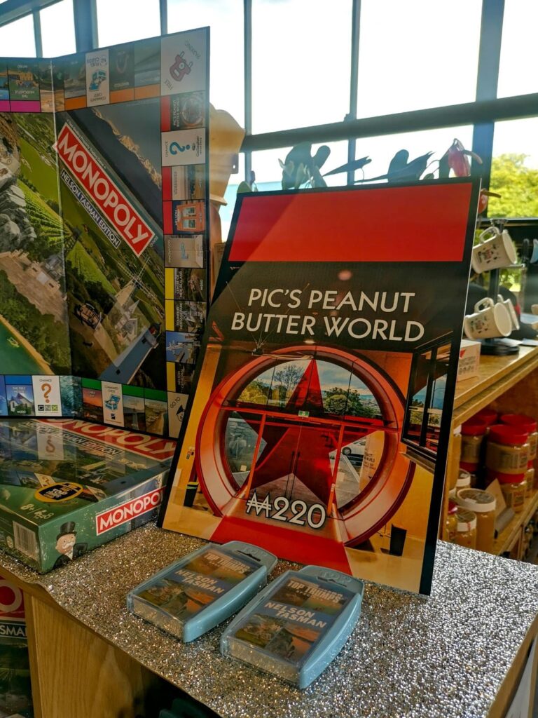 A display of local merchandise at Pic's Peanut Butter World in Nelson, including a Nelson Tasman edition of Monopoly and a large Monopoly-style card for the attraction.