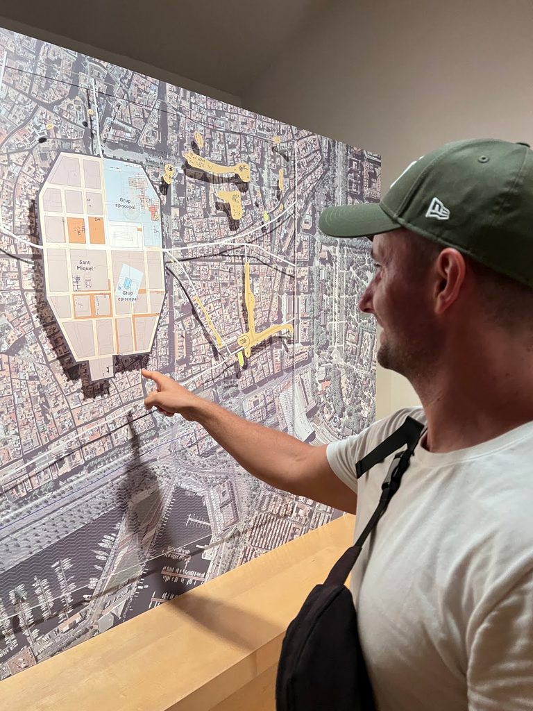 Allan pointing at an aerial historical display map inside Barcelona's History Museum.